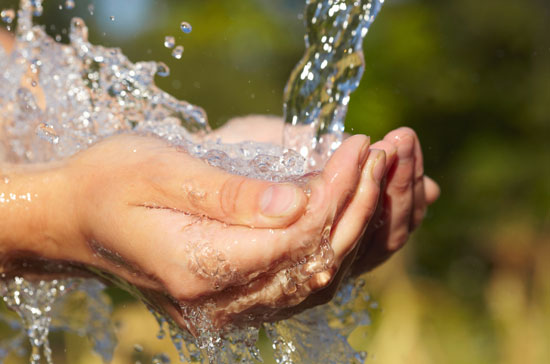 Water pouring into cupped hands